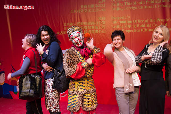 Foreigners learn to make a monkey face from a Peking Opera artist at the 'Beijing Salon – Experience Beijing'on Wednesday. [Photo by Chen Boyuan / China.org.cn]